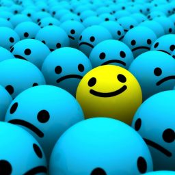 A cartoon happy face amongst sad faces