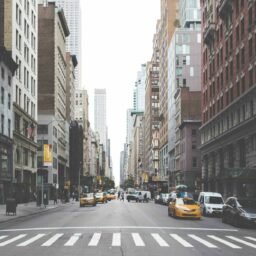 high-resolution photo of pedestrian, architecture, road, street, town, alley, city, urban, cityscape, downtown, taxi, cab, intersection, crosswalk, lane, publicdomain, automobiles, skyscrapers, pedestrians, buildings, windows, americanflag, infrastructure, neighbourhood, road surface, residential area, human settlement, metropolitan area, nonbuilding structure